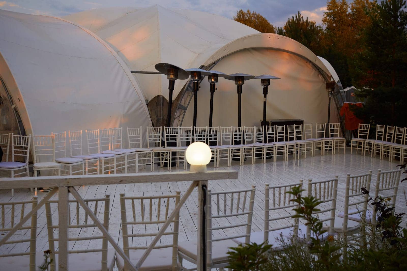 Photograph of dance floor and lighting equipment. White tents. Celebrations and weddings. Open area.