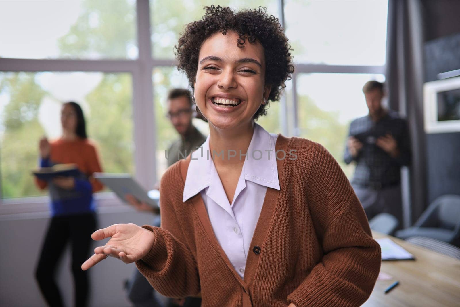 Successful businesswoman standing in creative office and looking at camera while smiling