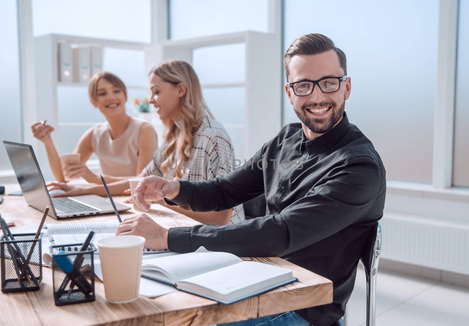 side view. smiling businessman in the workplace in a modern office.