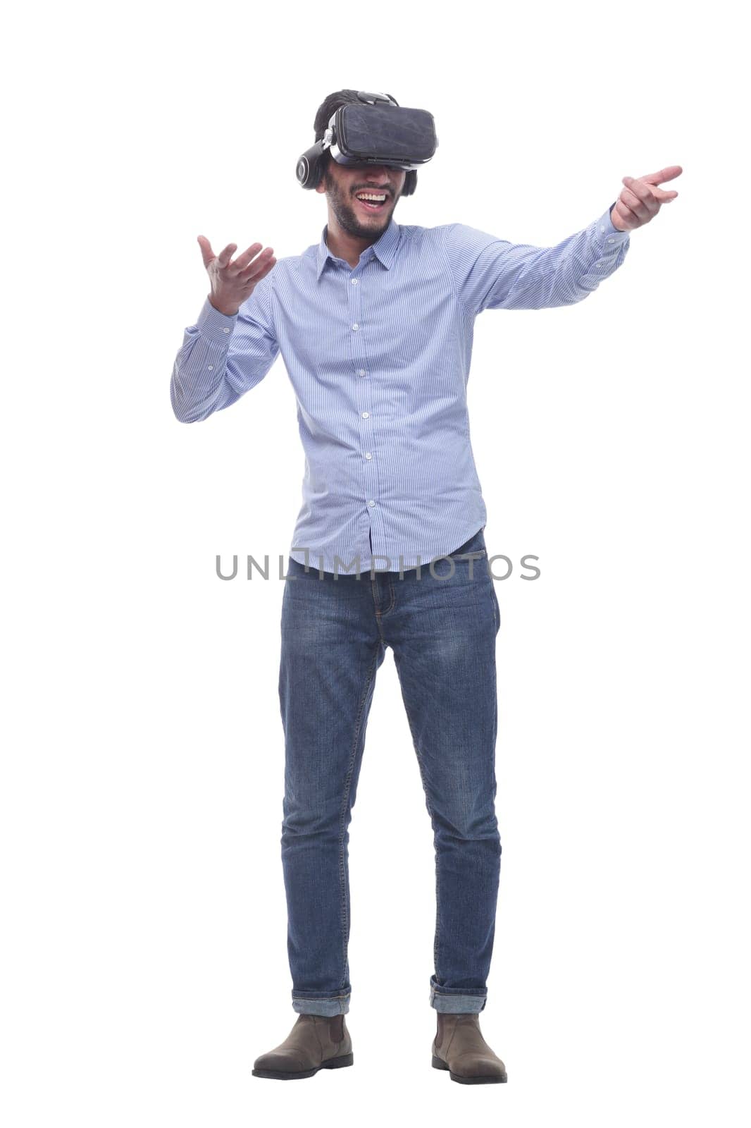 in full growth. smiling young man wearing virtual reality glasses. isolated on a white background.