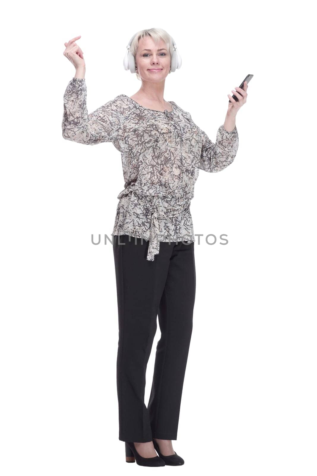 in full growth. young woman in headphones using her smartphone. isolated on a white background.