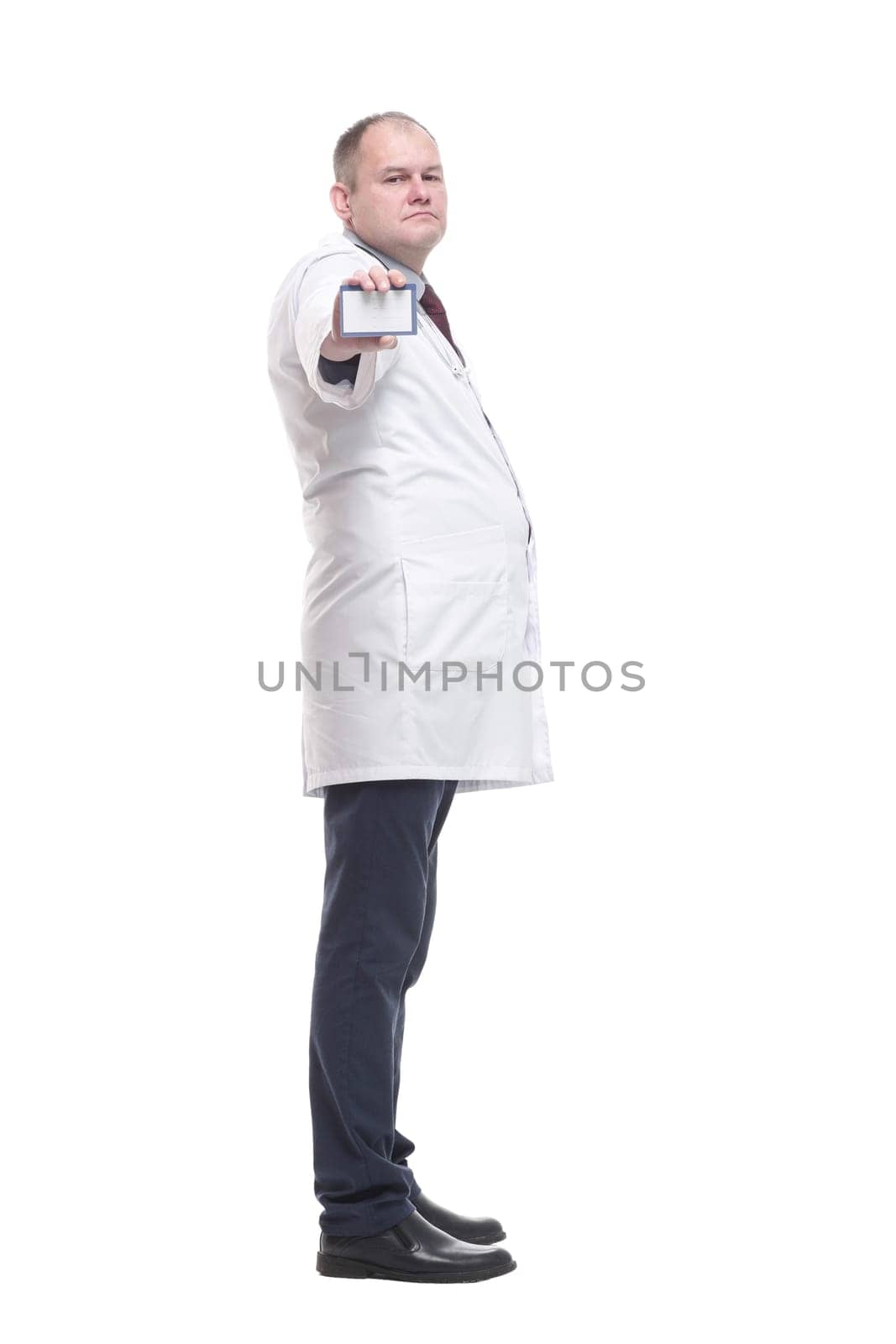 in full growth. competent doctor showing his visiting card. isolated on a white background.