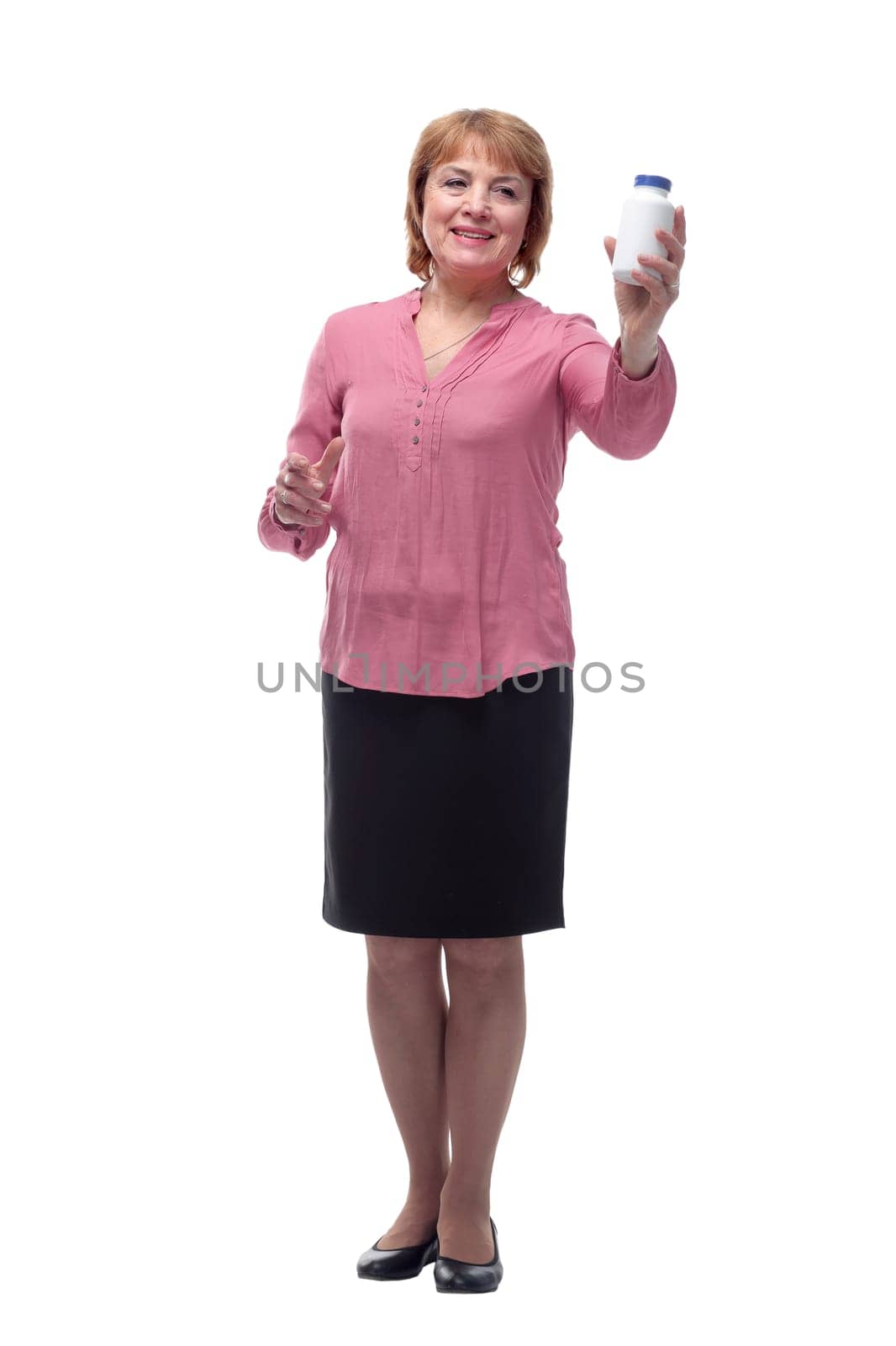 Middle aged woman holding glass bottle with pills, smiling and standing isolated on white background. Healthcare concept