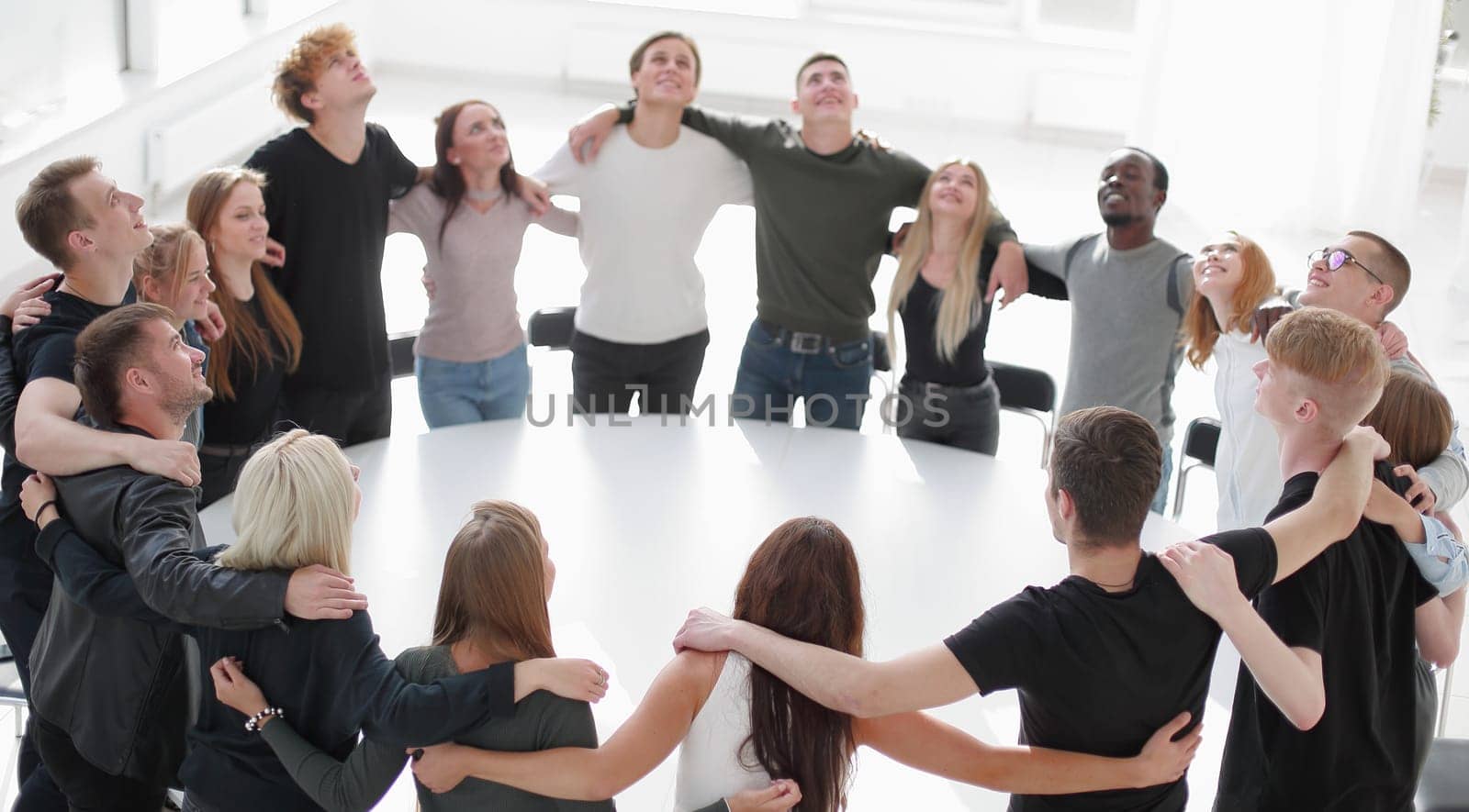 group of young like-minded people standing around a table . photo with copy space