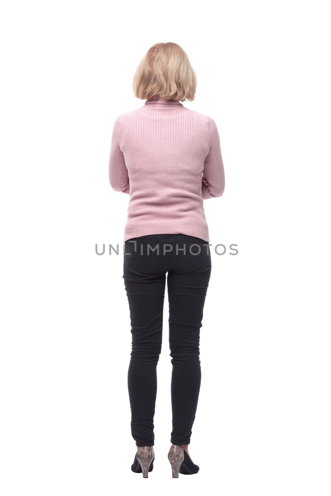 Back view of standing blonde woman in jeans and sweater isolated on white background