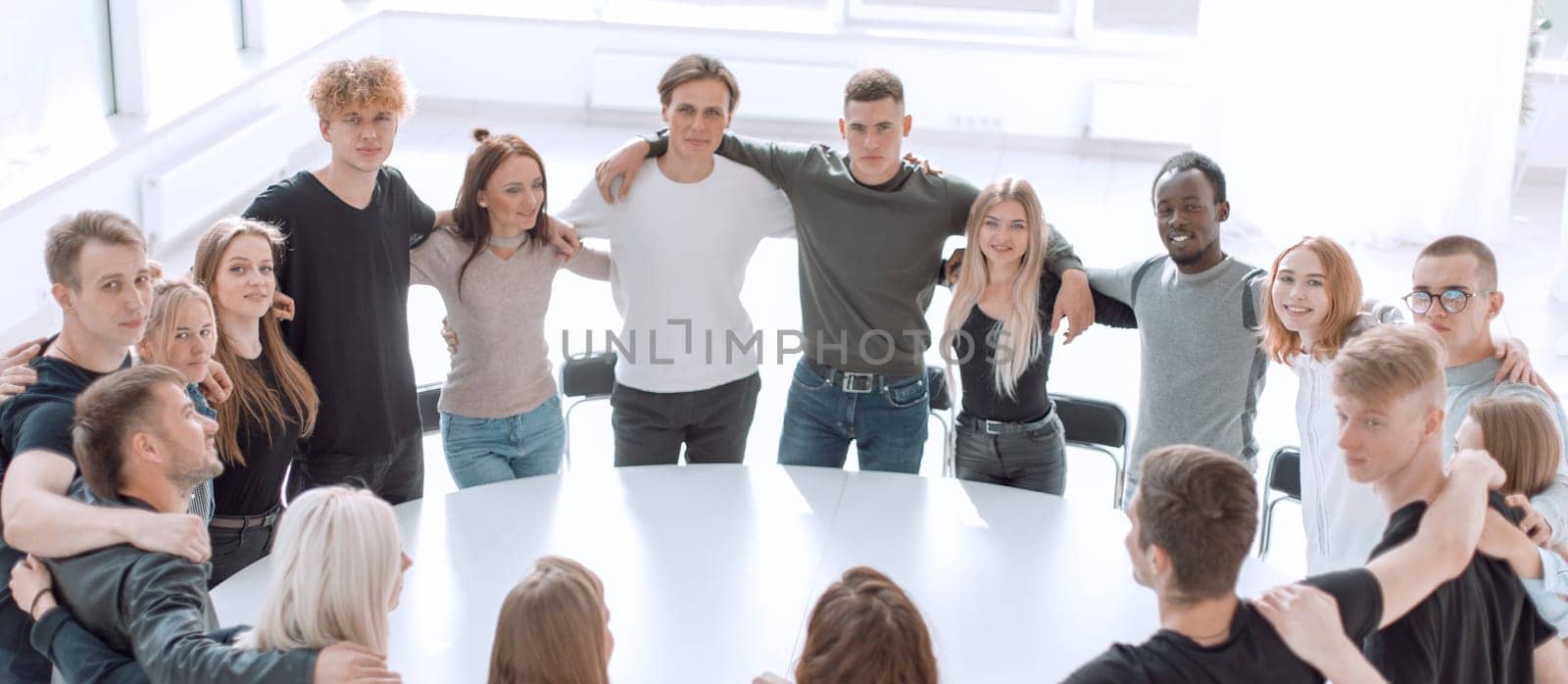 group of young like-minded people standing around a table . photo with copy space