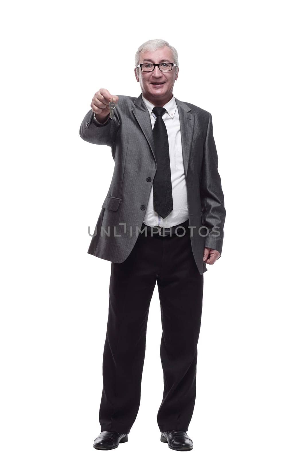 in full growth. business man with keys in hand. isolated on a white background.