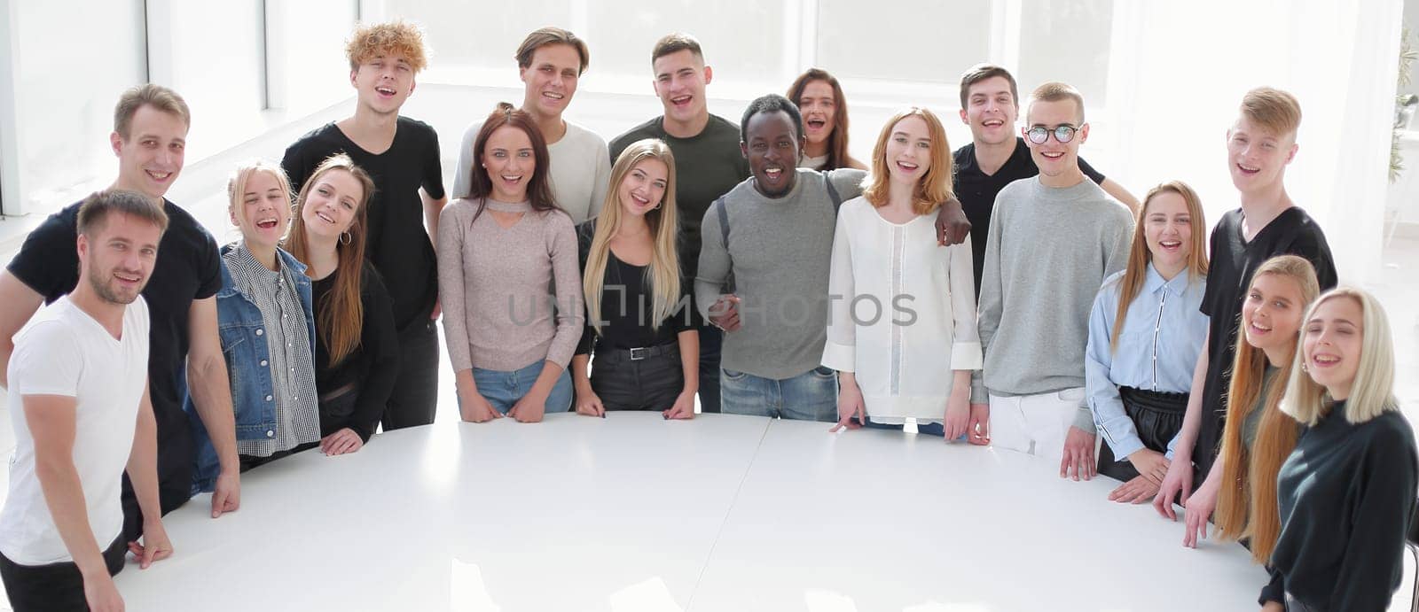 diverse young people standing near a round table. photo with copy space