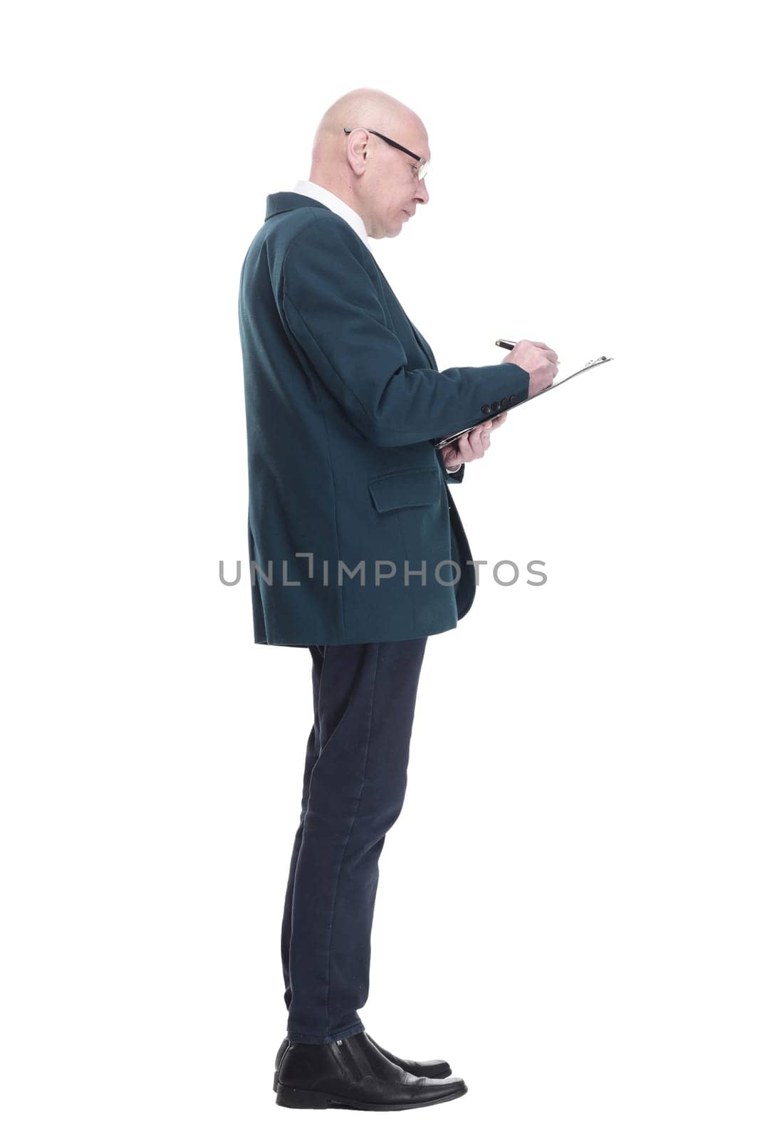 side view. serious business man writing something in the clipboard. isolated on a white background.