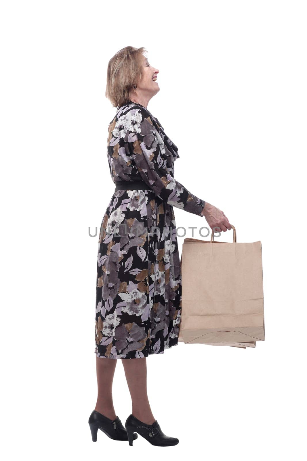 Portrait of happy senior woman posing with her shopping bag looking at camera and smiling