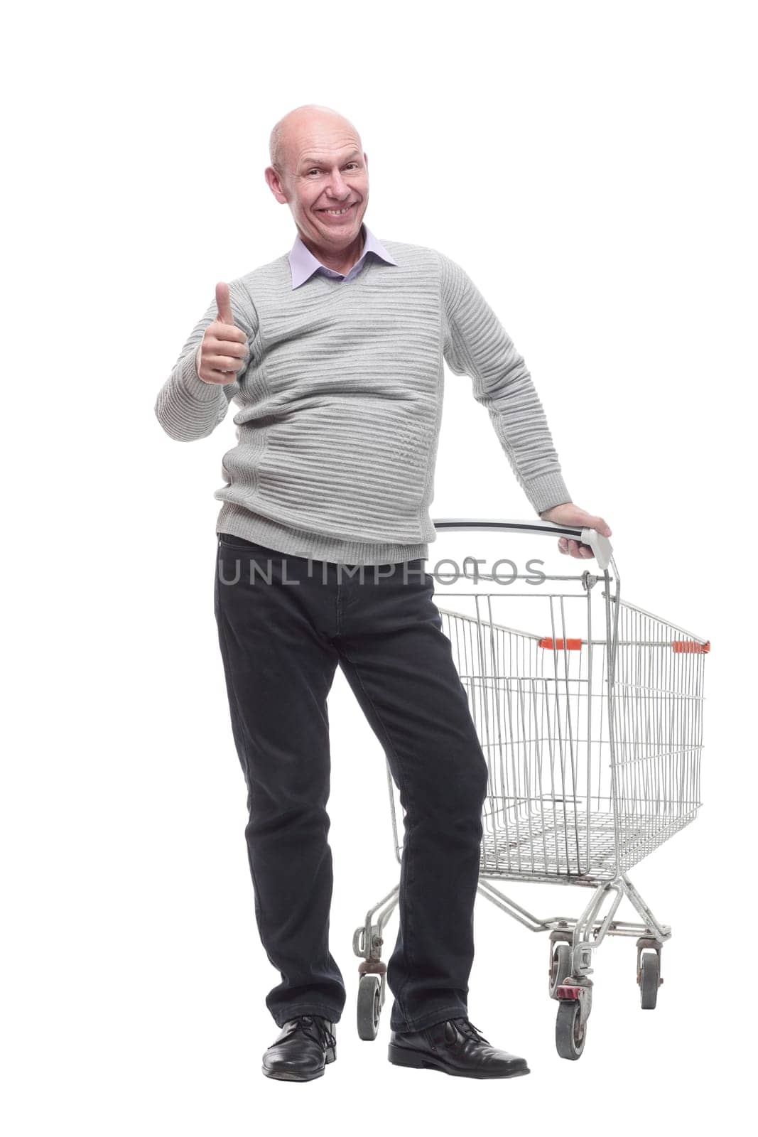 in full growth. a happy man with a shopping cart. isolated on a white background.
