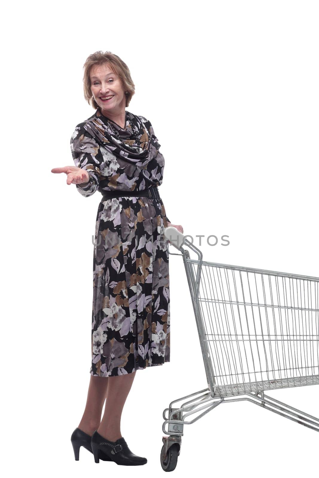 Profile of mature woman, pensioner shopping with shopping trolley looking at camera