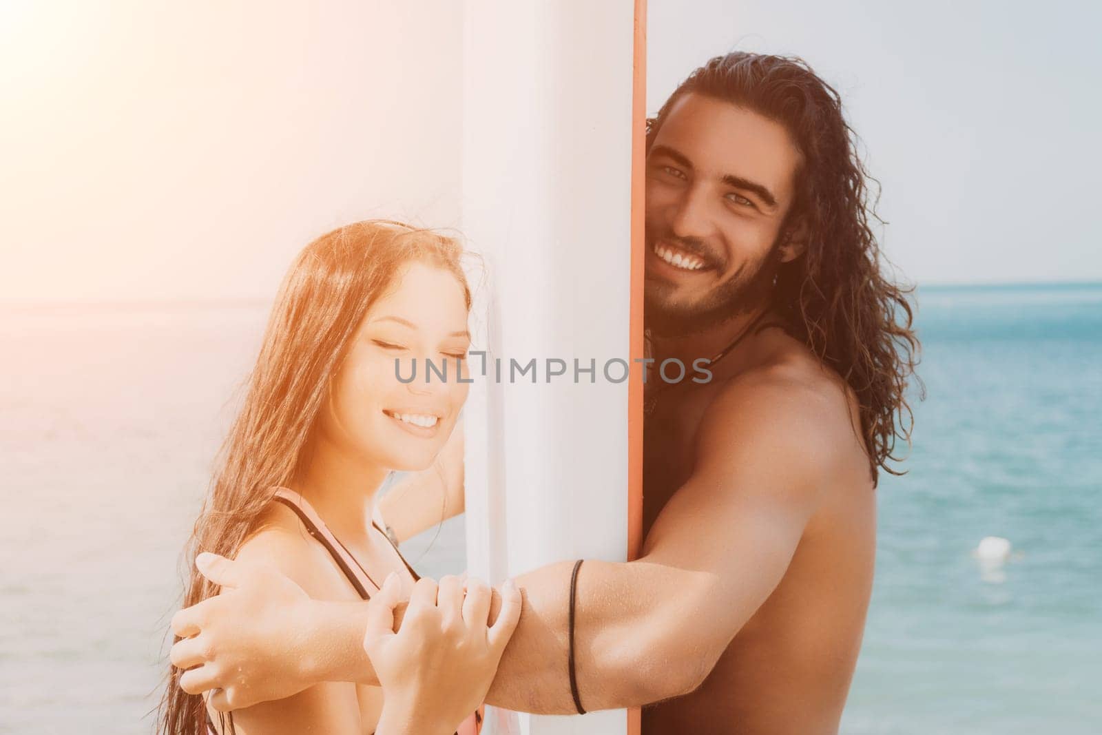 Woman man sea sup. Close up portrait of beautiful young caucasian woman with black hair and freckles looking at camera and smiling. Cute woman portrait in a pink bikini posing on sup board in the sea. by panophotograph