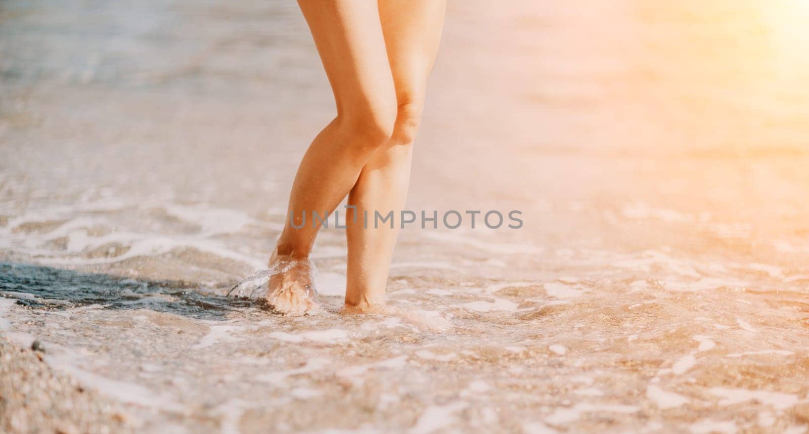 Barefoot woman standing in sea, summer vacation on beach resort. Naked female legs in transparent calm water