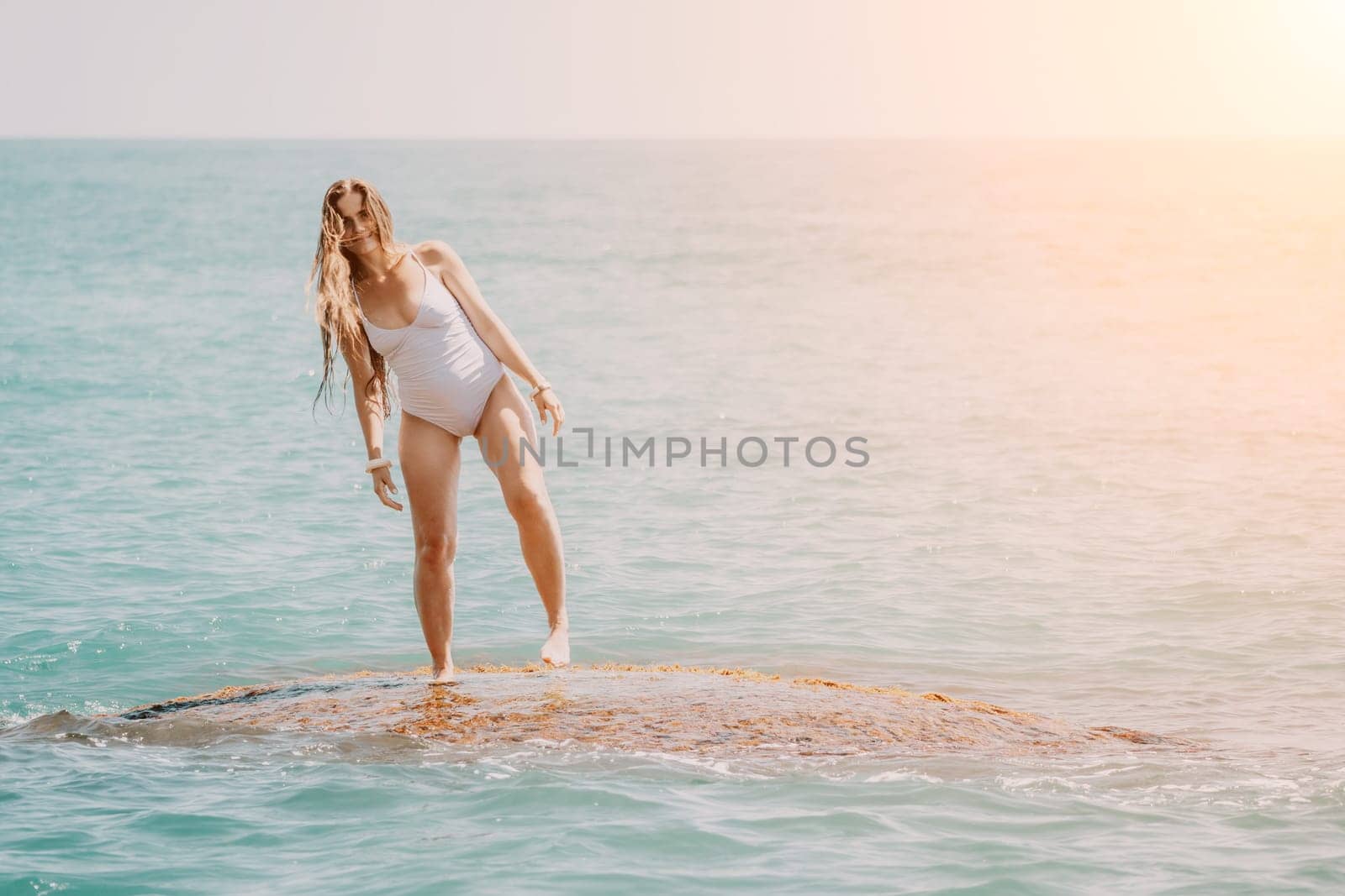 Woman sea yoga. Back view of free calm happy satisfied woman with long hair standing on top rock with yoga position against of sky by the sea. Healthy lifestyle outdoors in nature, fitness concept.