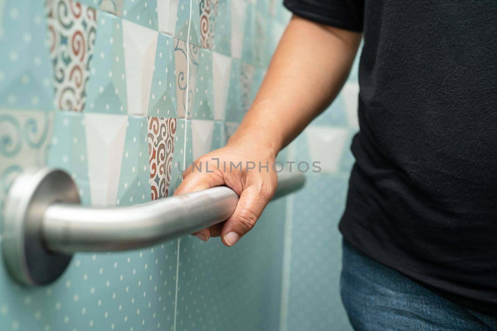 Asian elderly woman use bathroom handle security in toilet, healthy strong medical concept. by pamai