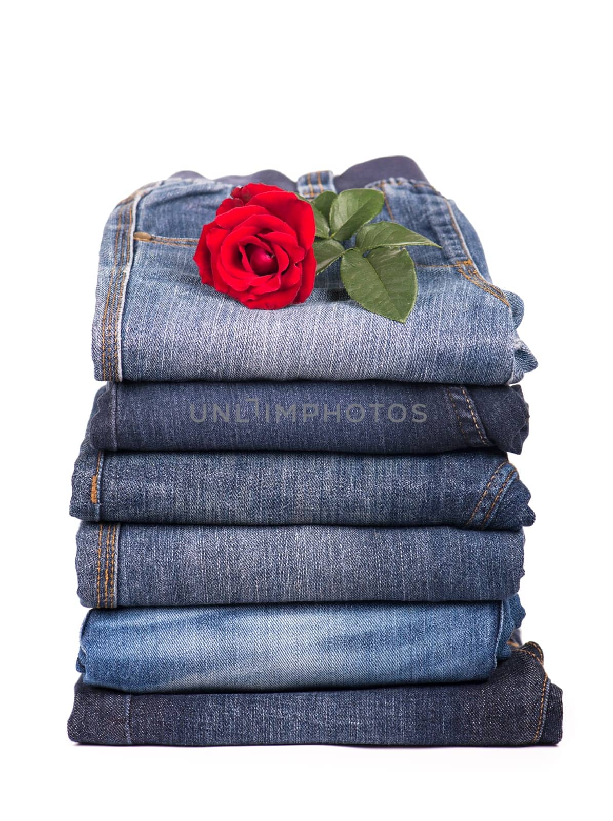 jeans clothes are put by a pile and a red rose by aprilphoto