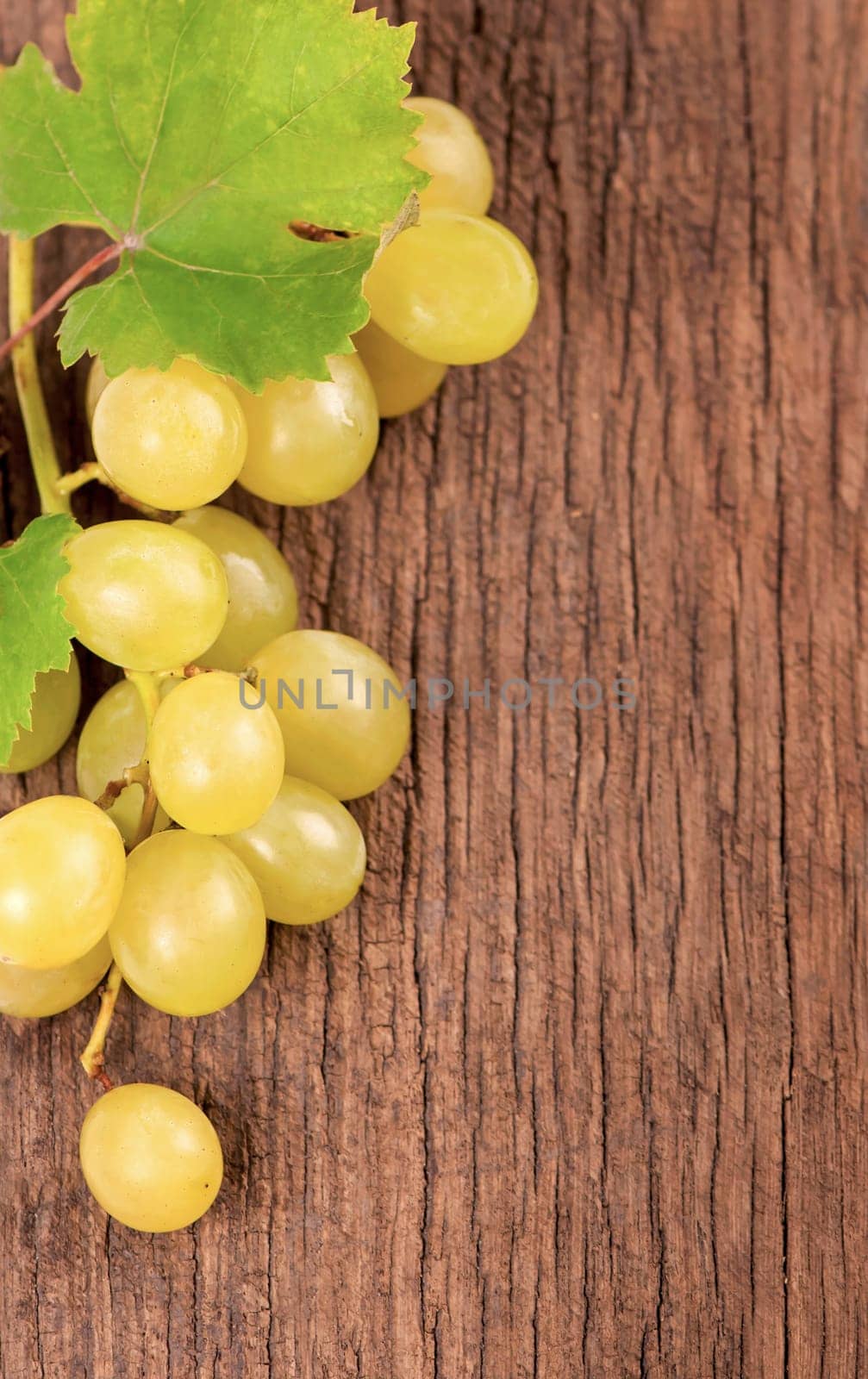 Bunches of fresh ripe grapes on a wooden textural surface.