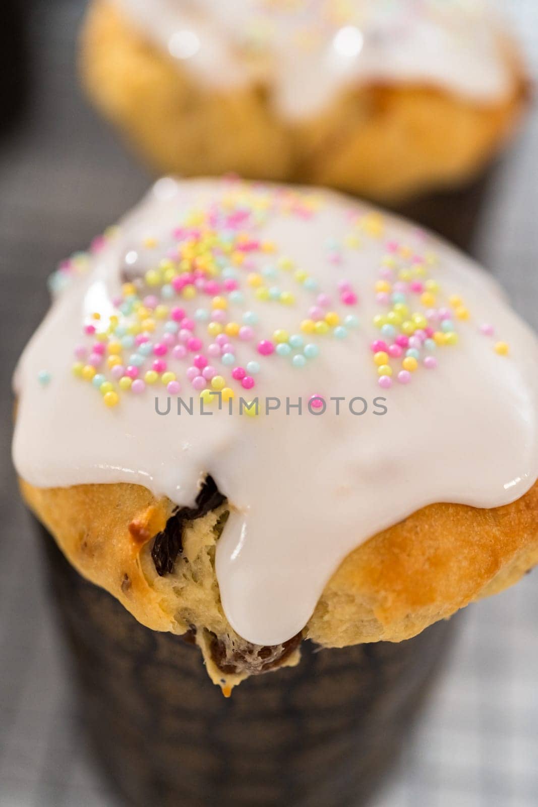 Glazing mini Easter bread kulich with a white lemon glaze.