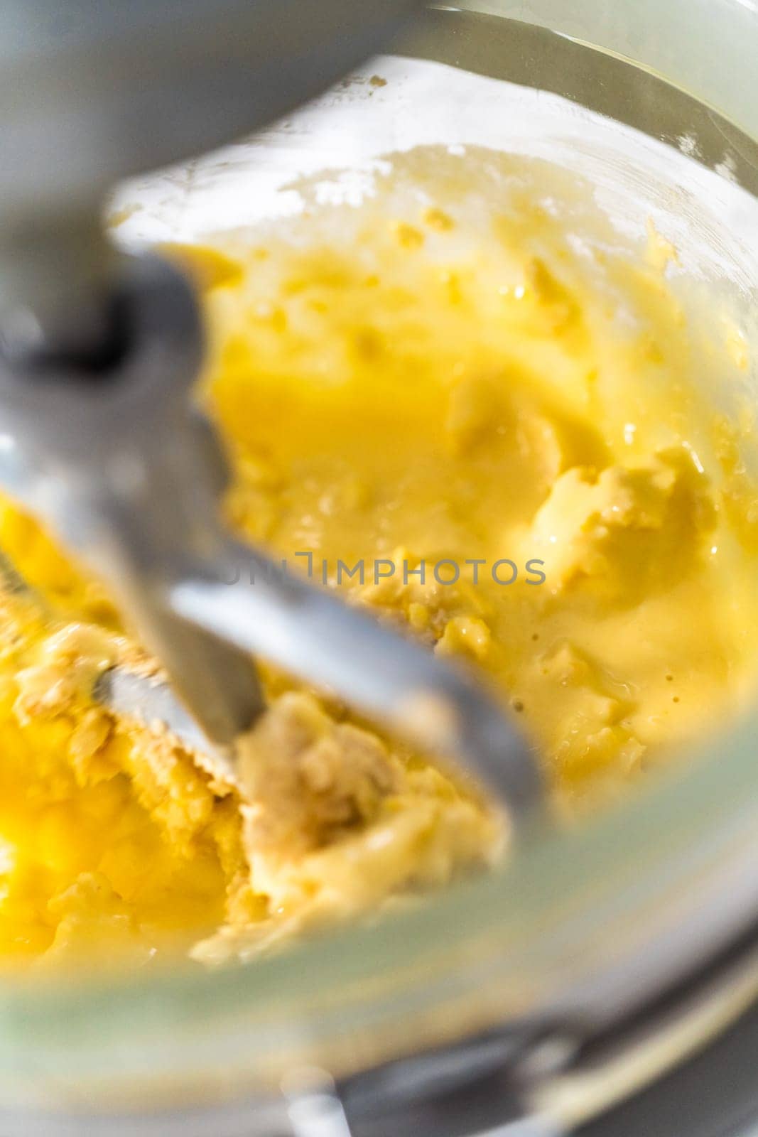 Mixing ingredients in kitchen mixer to bake mini Easter bread kulich.