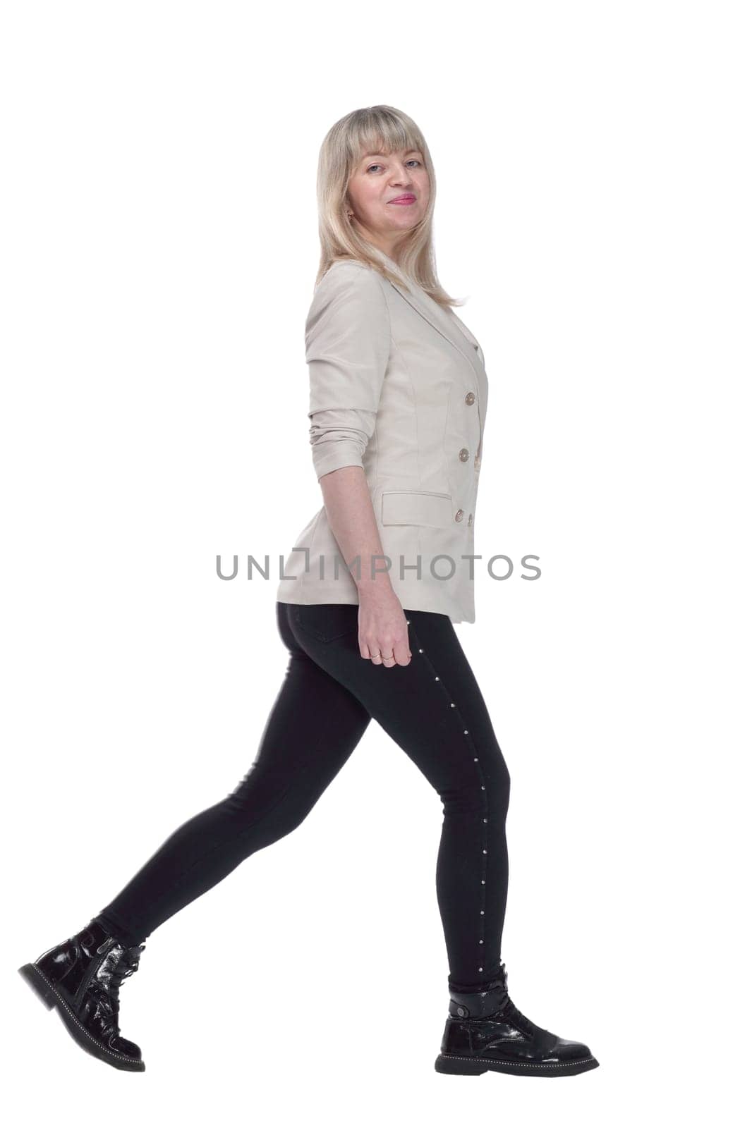 in full growth. smiling woman in a white jacket striding confidently forward. isolated on a white background.