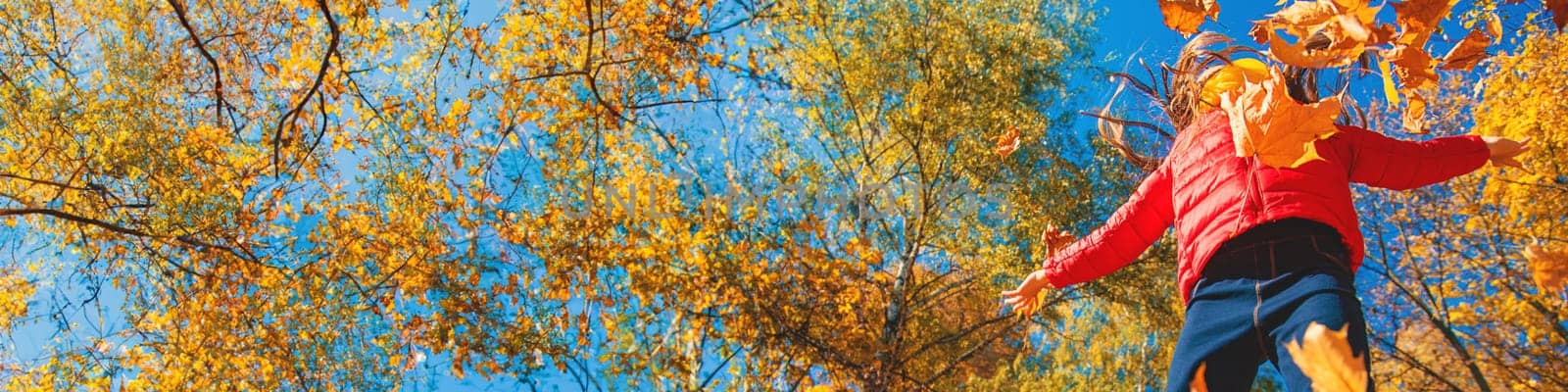 Autumn child in the park with yellow leaves. Selective focus. by yanadjana