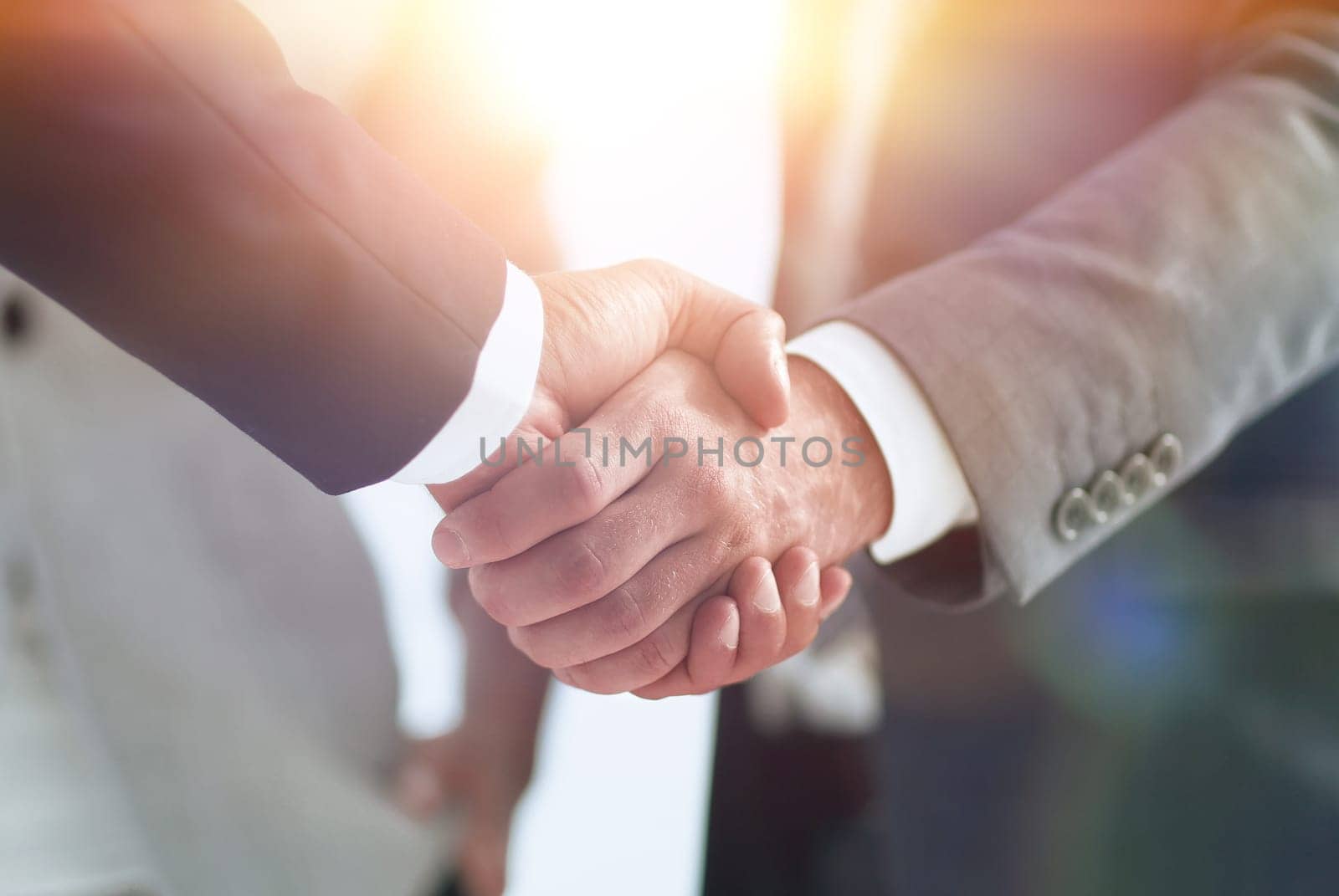 closeup of handshake of business partners on the background of business team