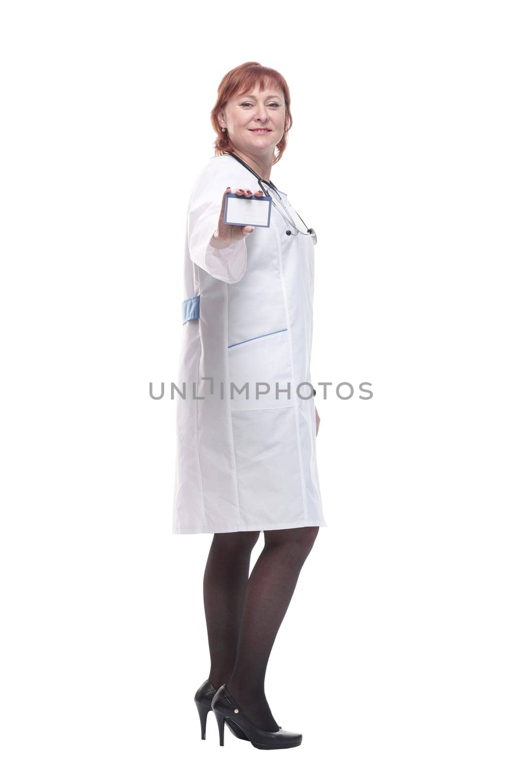 in full growth. competent female doctor showing her business card . isolated on a white background.
