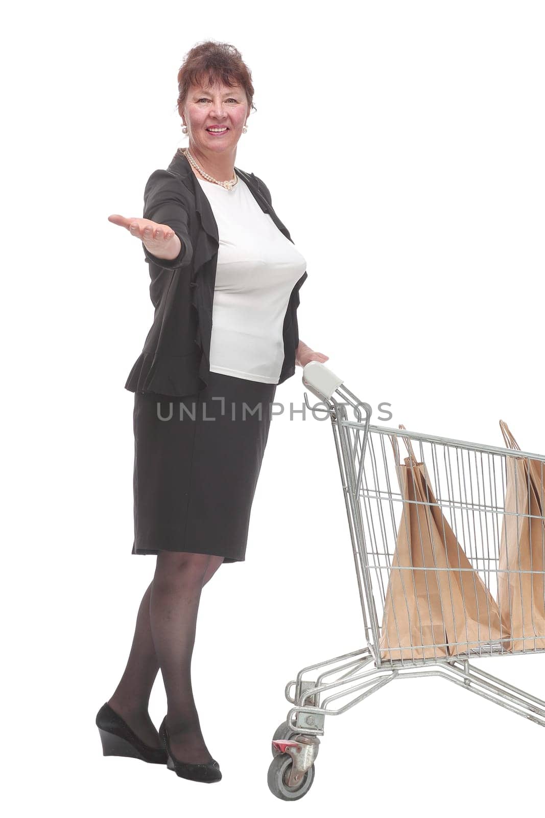 Full length portrait of a woman pushing a shopping trolley isolated on white background