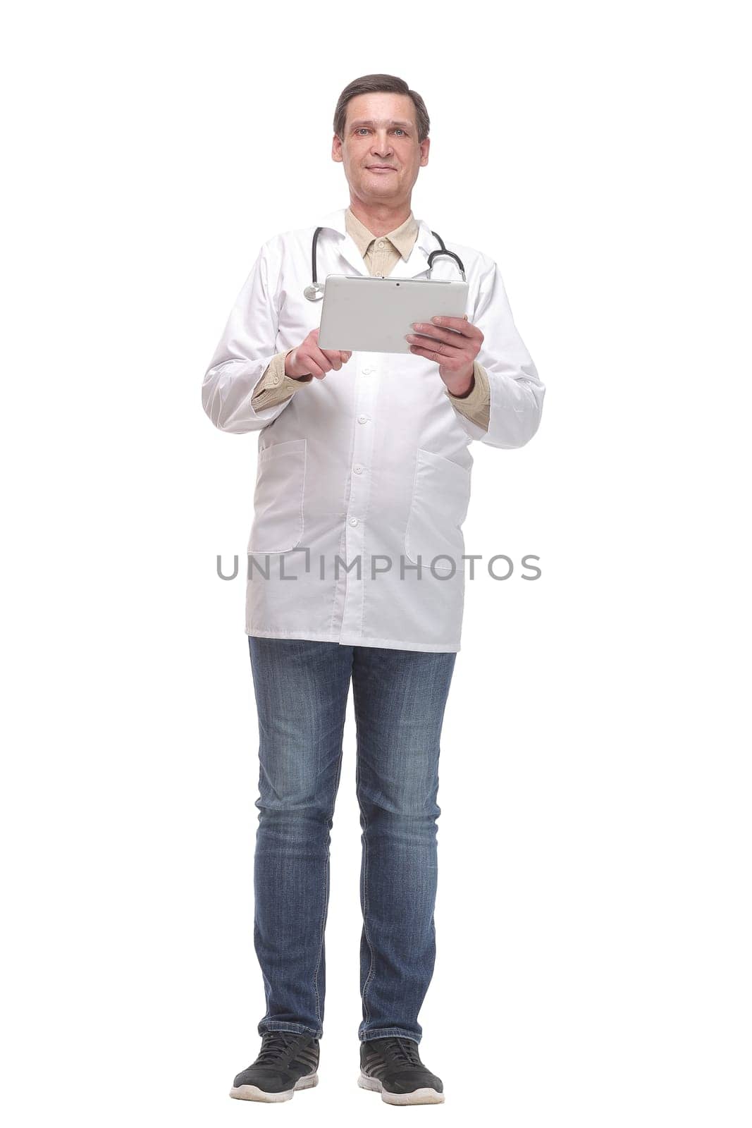 Front view of serious doctor working on a digital tablet isolated on white background