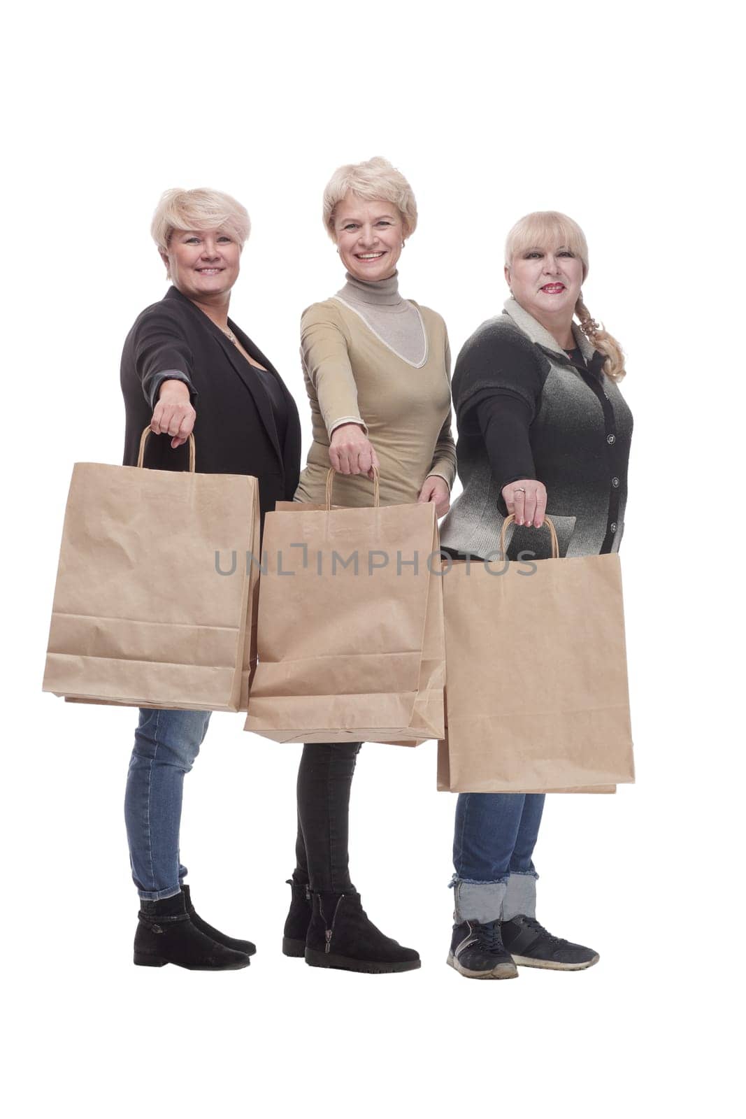 in full growth. three happy women with shopping bags. isolated on a white background.