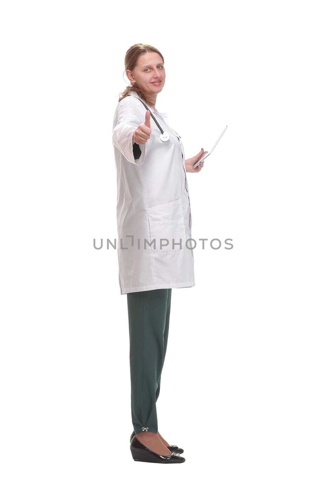 Side view of happy female doctor writing patient chart on digital tablet over white background