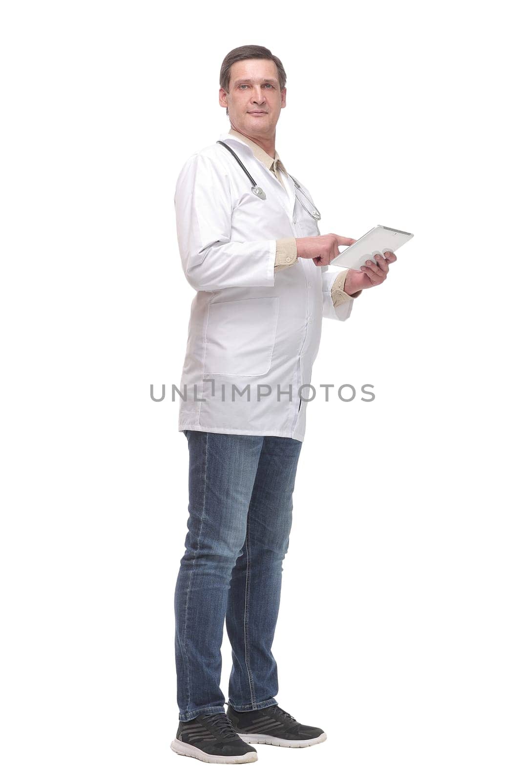 Side view of confident doctor wearing uniform and glasses using digital tablet. Isolated on white background
