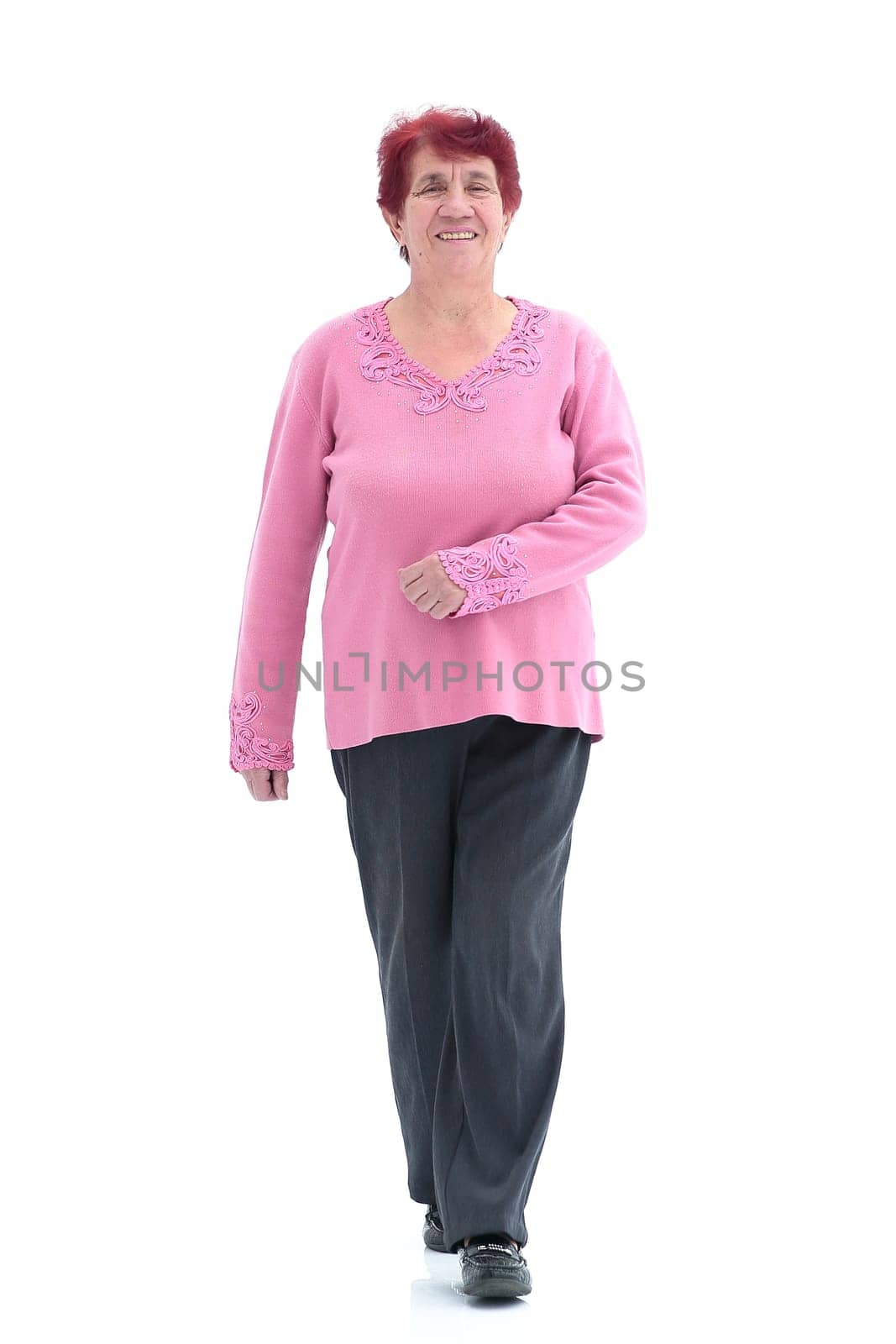 confident older woman walks forward. isolated on a white background