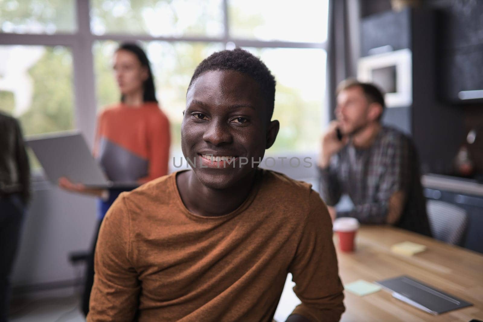 Portrait of happy African American small business owner posing with hands folded