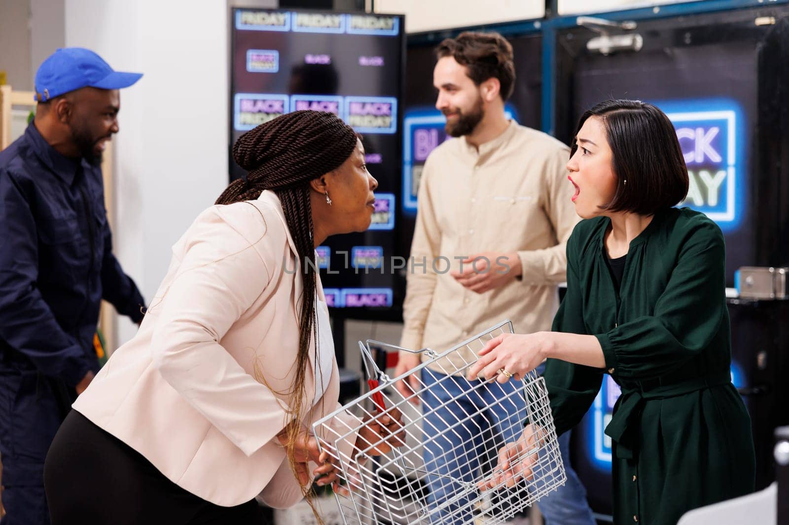 Crazy sale. Two angry female shoppers fighting for last shopping basket at store during Black Friday sales. Diverse women consumers fighting while hunting for best deals and bargains, arguing in store