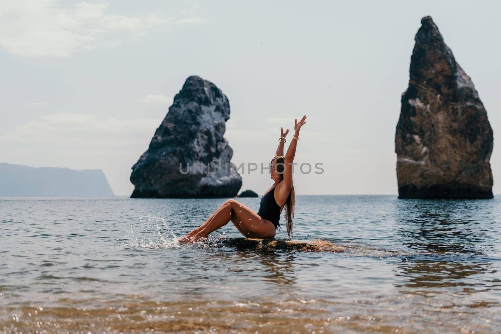 Woman summer travel sea. Happy tourist enjoy taking picture outdoors for memories. Woman traveler posing on the beach at sea surrounded by volcanic mountains, sharing travel adventure journey by panophotograph