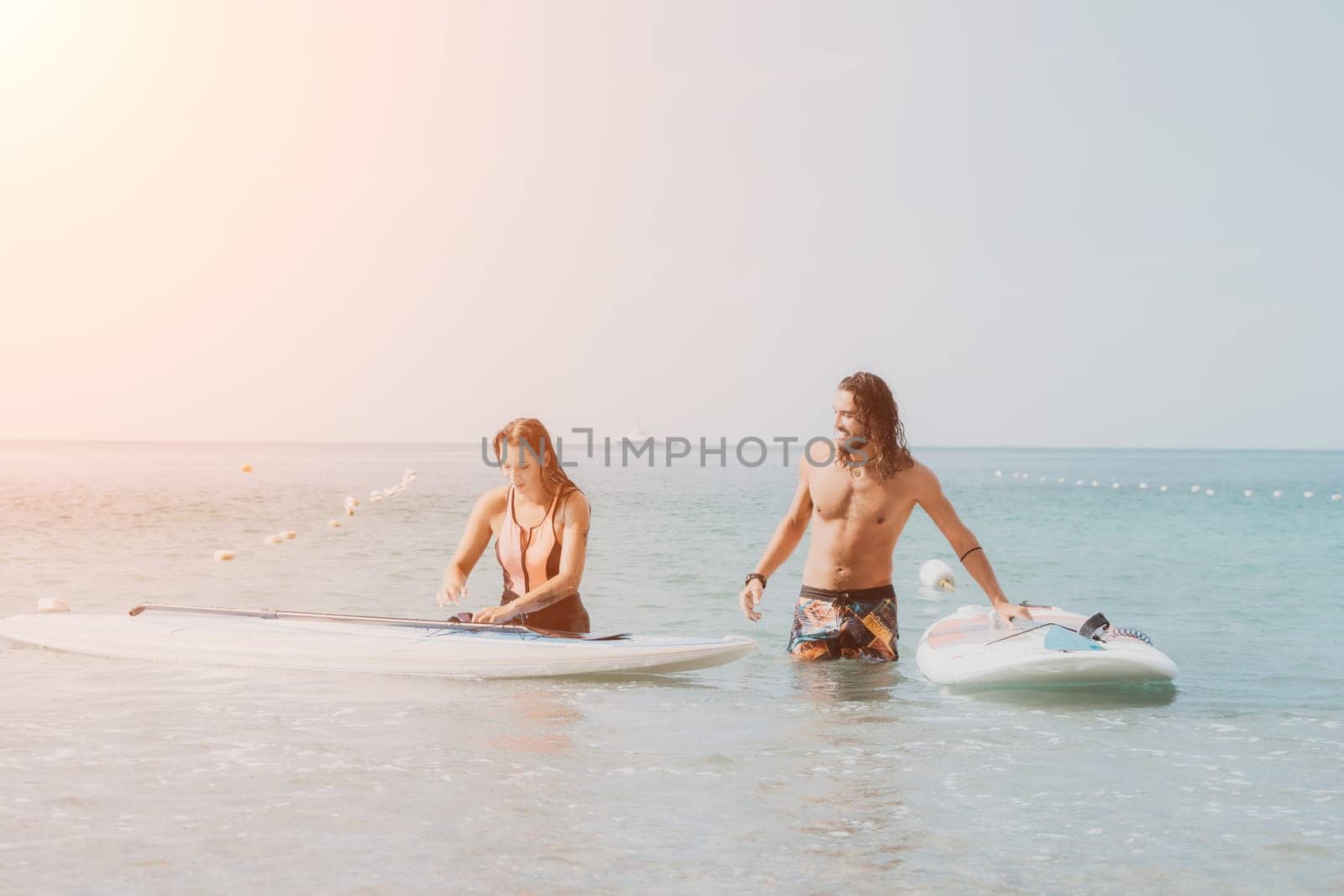 Woman man sea sup. Close up portrait of beautiful young caucasian woman with black hair and freckles looking at camera and smiling. Cute woman portrait in a pink bikini posing on sup board in the sea