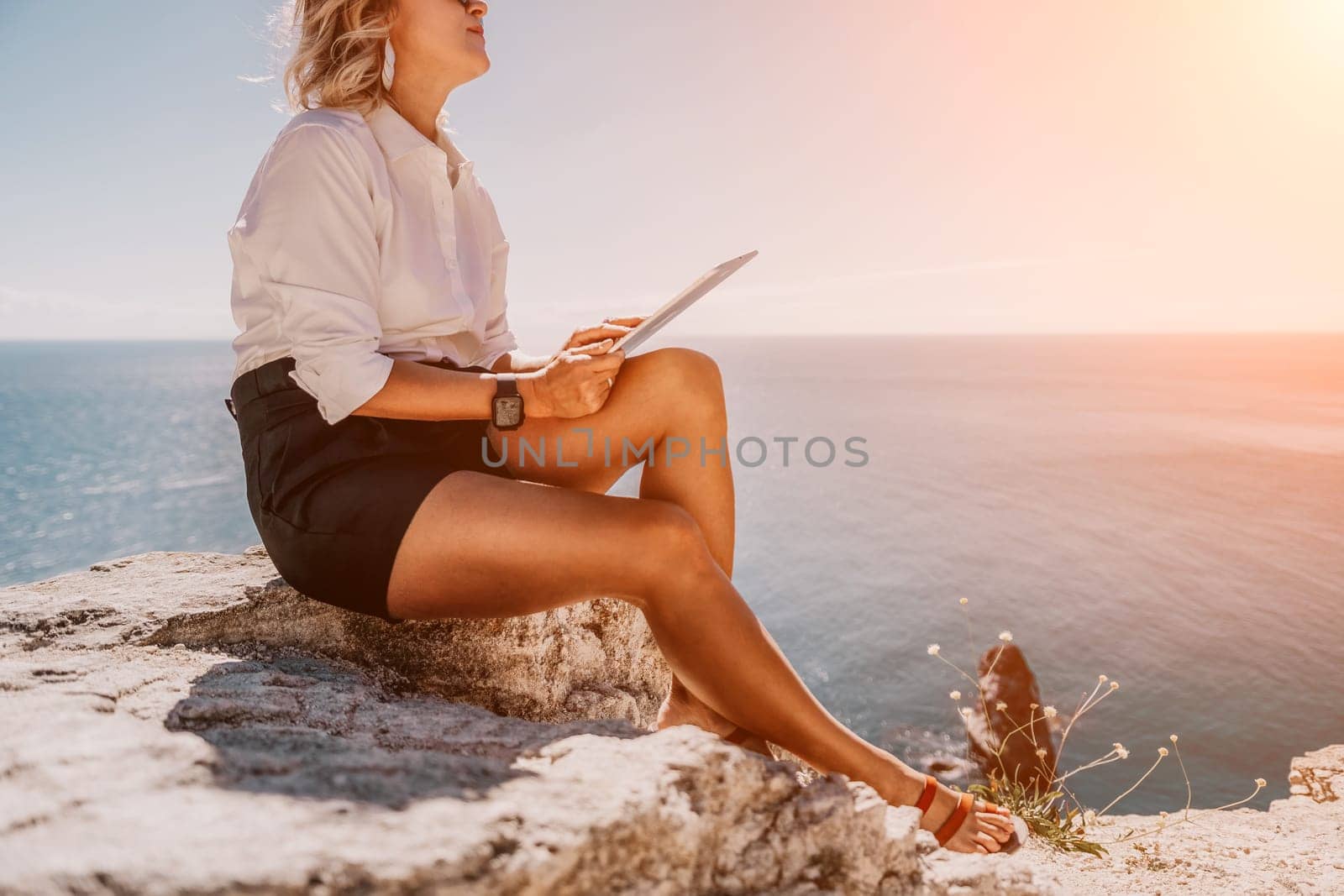 Digital nomad, Business woman working on tablet pc pad computer by the sea. Pretty lady with tablet pc on the sea, makes a business transaction online from distance. Freelance, remote work on vacation by panophotograph