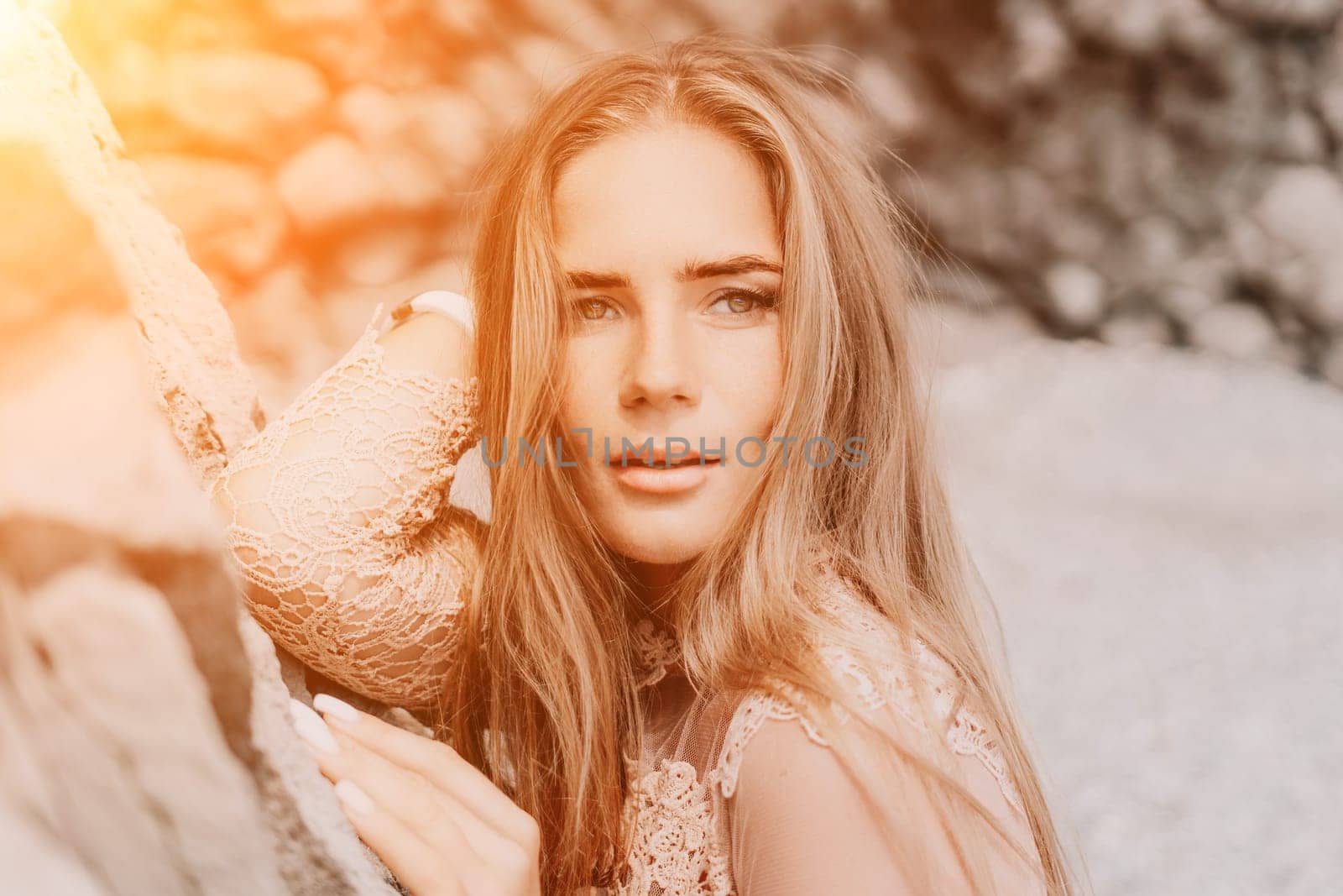 Woman summer travel sea. Happy tourist in beige dress enjoy taking picture outdoors for memories. Woman traveler posing on the beach surrounded by volcanic mountains, sharing travel adventure journey by panophotograph