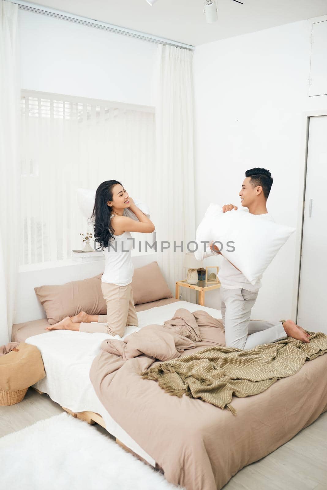 Picture showing happy couple having pillow fight