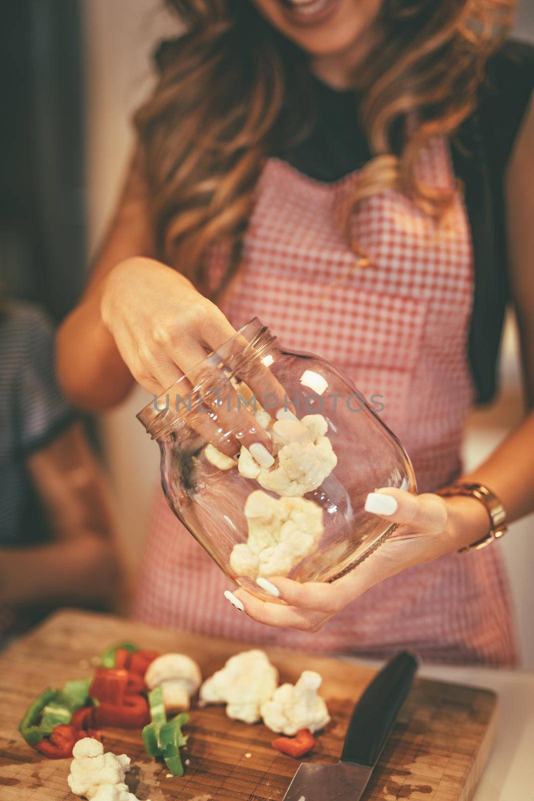 Close-up of a young woman preparing for marinating cauliflower and making healthy meal in her home kitchen.  