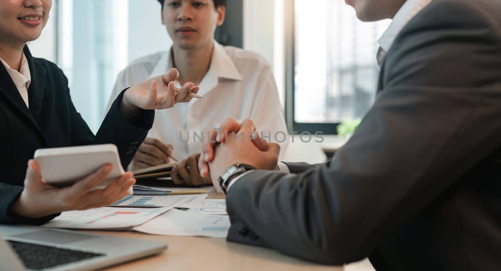 Asian business adviser meeting to analyze and discuss the situation on the financial report in the meeting room. Investment Consultant, Financial Consultant, Financial advisor and accounting concept.