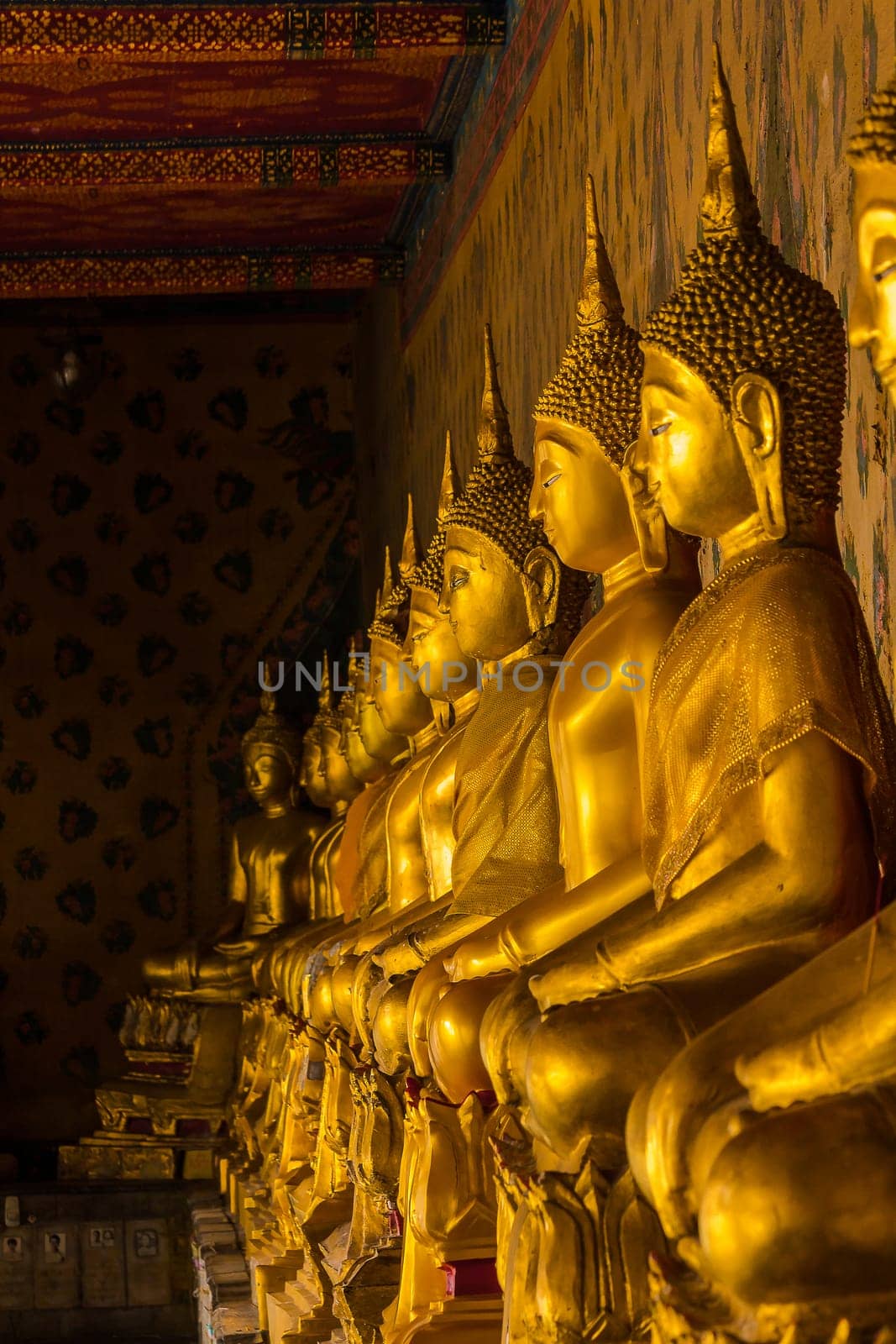 Golden Buddha statue on the pedestal with old walls