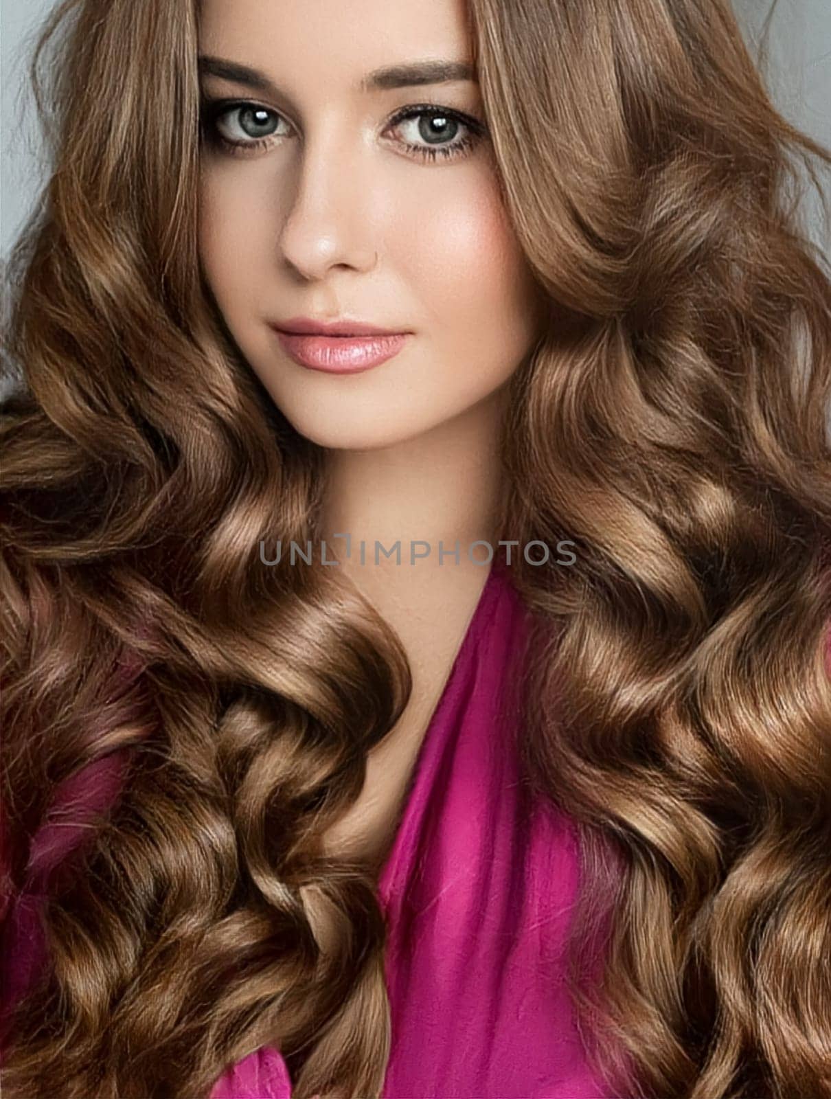 Beautiful woman with curly volume hairstyle, long luxurious hair and beauty make-up, glamorous look face portrait for luxury fashion and natural cosmetics idea