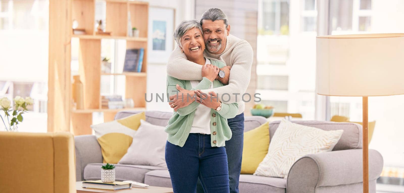 Portrait, hug and senior couple with love, home and happiness with care, bonding and retirement. Lounge, old man and mature woman embrace, affection and loving together with marriage and relationship by YuriArcurs