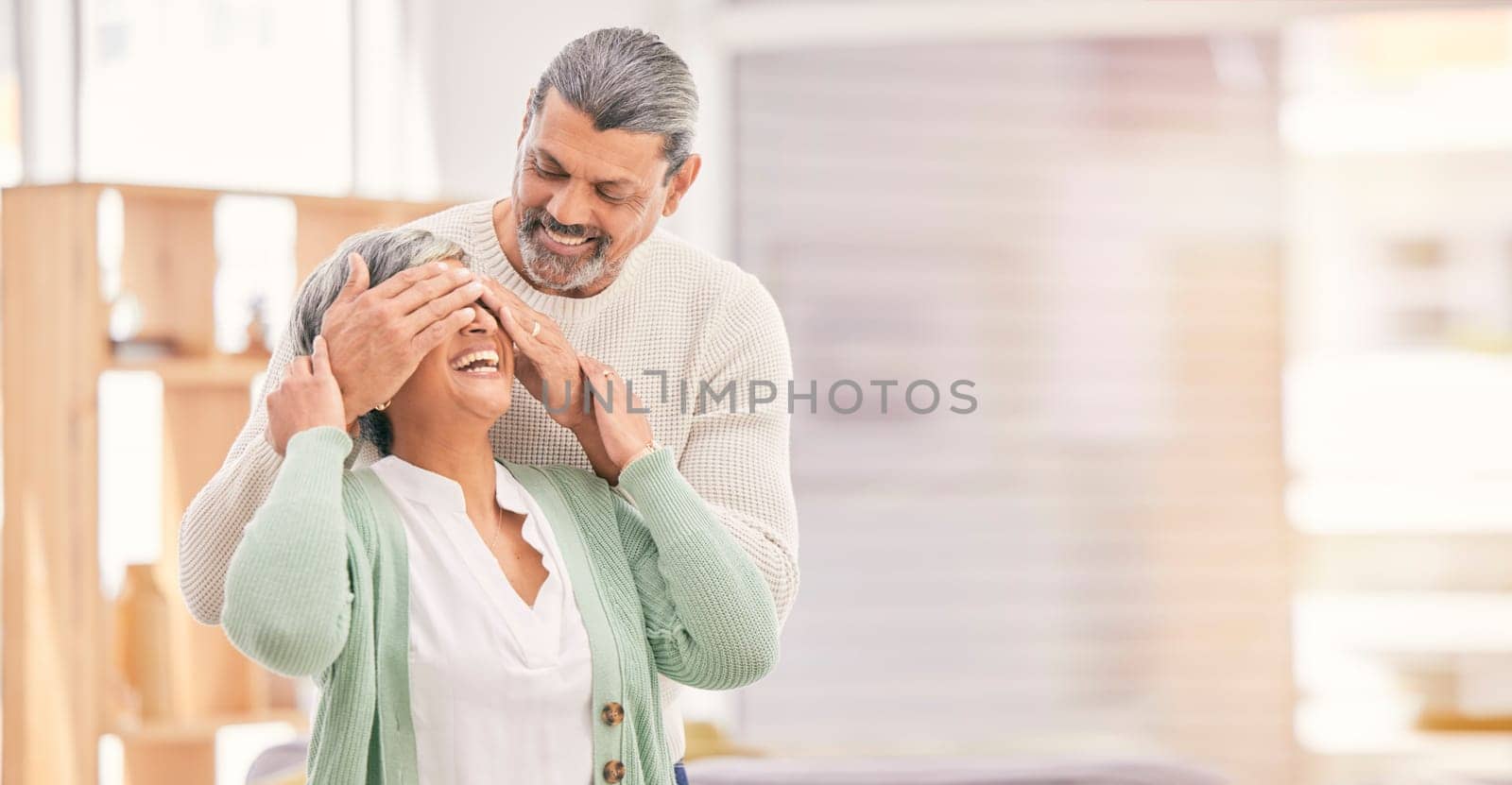 Eyes closed, surprise and elderly couple in a retirement home and living room together. Mockup space, present and senior people in marriage with love, support and care with romance and happy laugh.