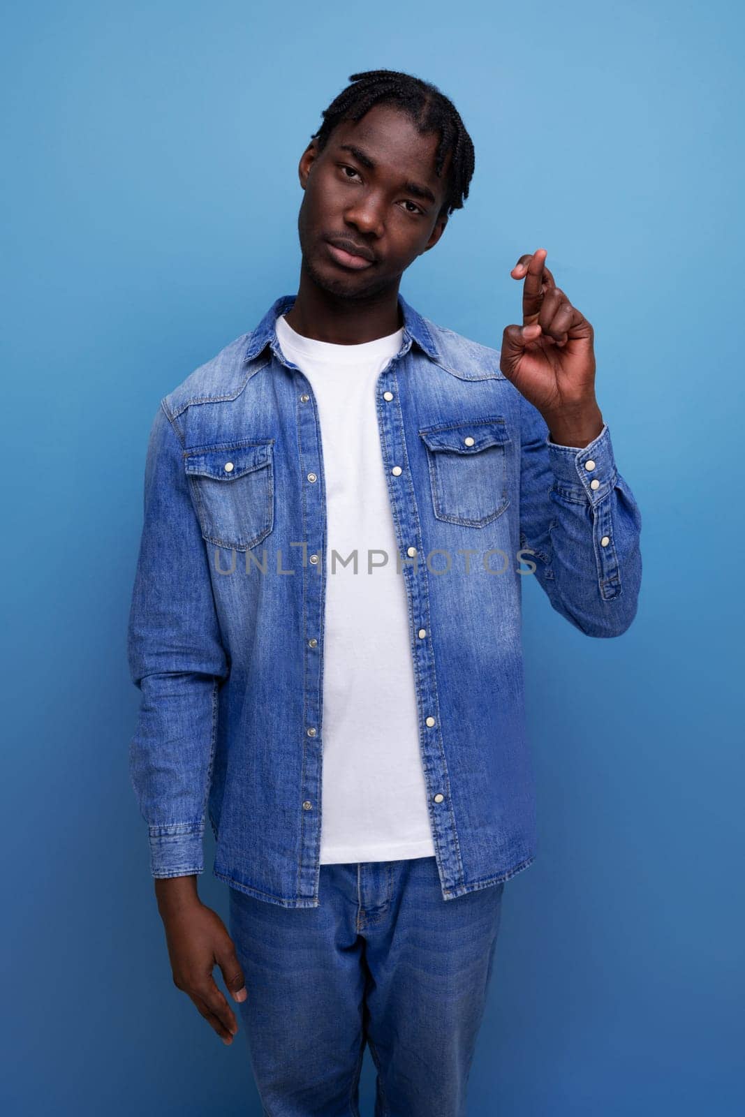 close-up portrait of a handsome young stylish american guy with curls in denim clothes.