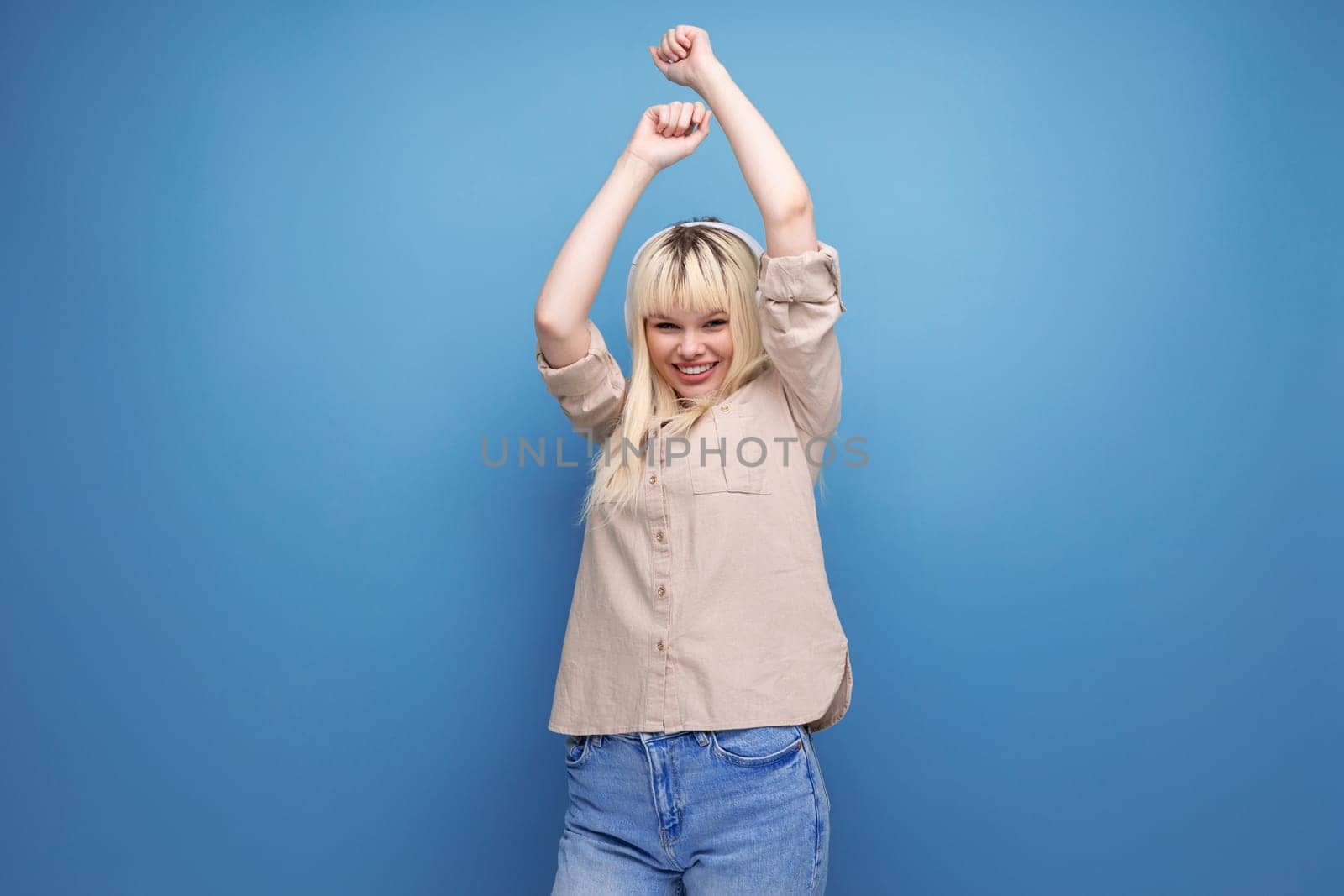 adorable blonde young girl uses headphones to listen to the radio.