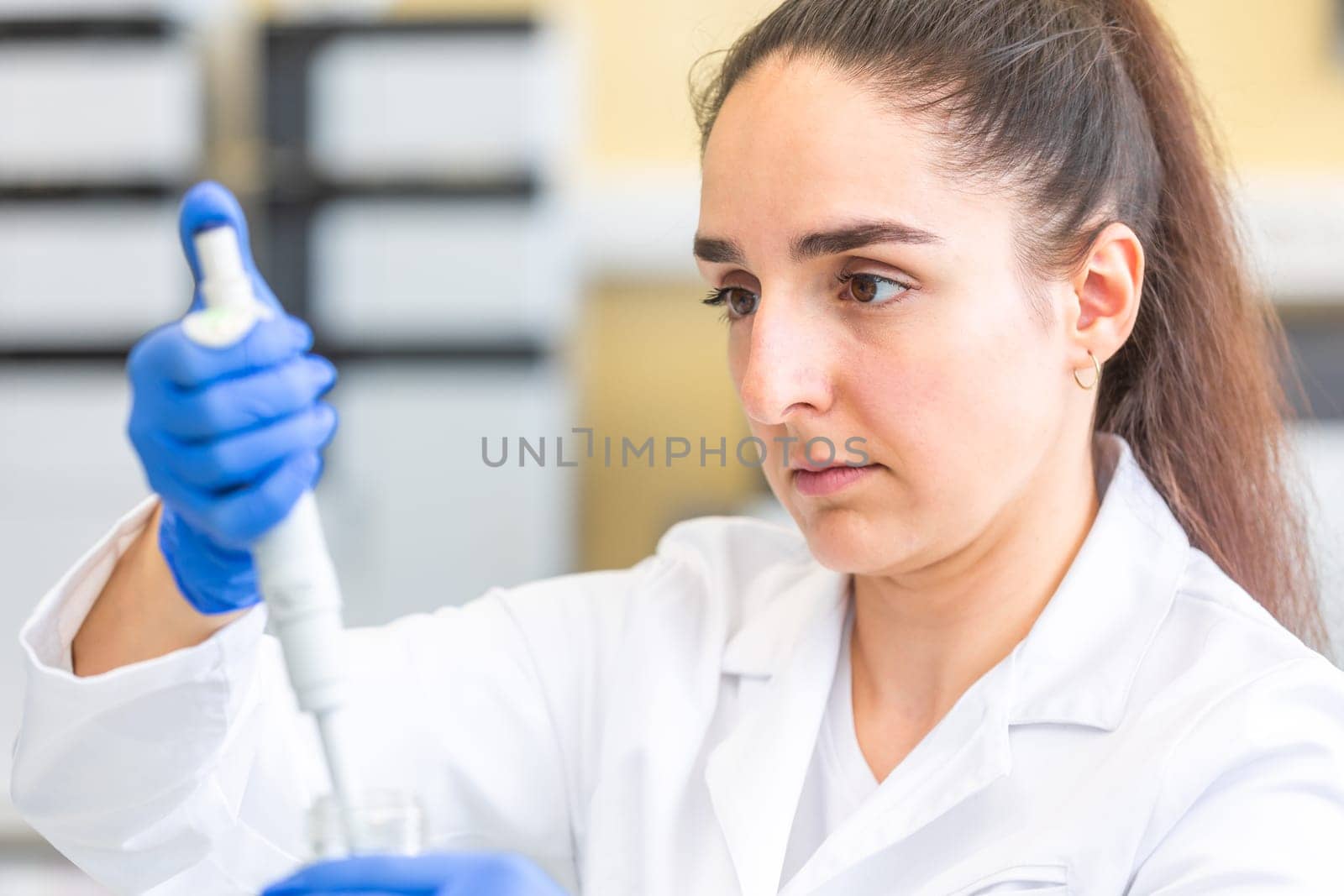 Young woman scientist in a research laboratory creating a scientific experiment, laboratory concept by Kadula